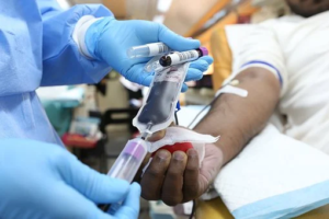 Paramedic staff wearing blue gloves collecting patient’s blood