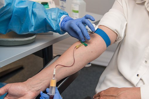 Man donating blood to a phlebotomist in mobile lab draw services in MD